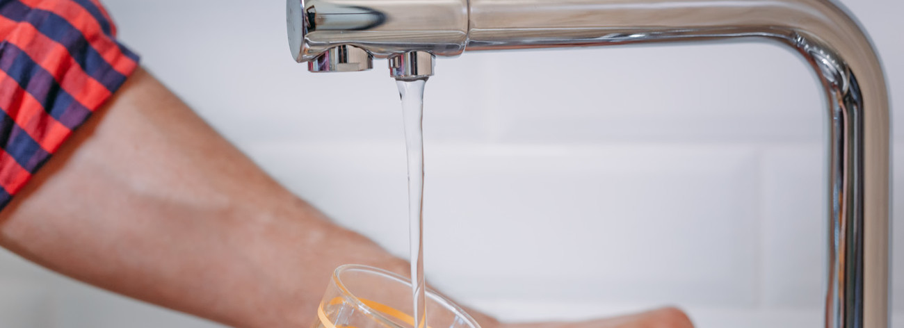 Personne se servant de l'eau au robinet